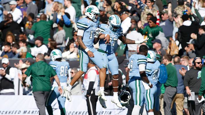 Jan 4, 2020; Fort Worth, Texas, USA; Tulane Green Wave quarterback Justin McMillan (12) celebrates a touchdown with Tulane Green Wave running back Ygenio Booker (27) in the third quarter against the Southern Miss Golden Eagles at Amon G. Carter Stadium. Mandatory Credit: Tim Heitman-USA TODAY Sports Jan 4, 2020; Fort Worth, Texas, USA; Tulane Green Wave quarterback Justin McMillan (12) celebrates a touchdown with Tulane Green Wave running back Ygenio Booker (27) in the third quarter against the Southern Miss Golden Eagles at Amon G. Carter Stadium. Mandatory Credit: Tim Heitman-USA TODAY Sports