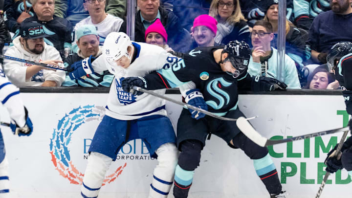 Feb 6, 2025; Seattle, Washington, USA;  Toronto Maple Leafs forward Pontus Holmberg (29) and  forward Andre Burakovsky (95) battle for the puck during the third period at Climate Pledge Arena. Mandatory Credit: Stephen Brashear-Imagn Images