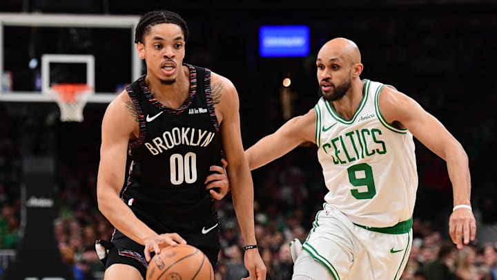 Feb 27, 2026; Boston, Massachusetts, USA; Brooklyn Nets forward Josh Minot (00) controls the ball while Boston Celtics guard Derrick White (9) defends during the first half at TD Garden. Mandatory Credit: Bob DeChiara-Imagn Images