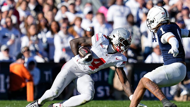 Ohio State Buckeyes wide receiver Jeremiah Smith (4) loses his footing on the grass turf as he tries to elude Penn State Nittany Lions safety Jaylen Reed (1) after making a catch during the NCAA football game at Beaver Stadium in University Park, Pa. on Monday, Nov. 4, 2024. Ohio State won 20-13.