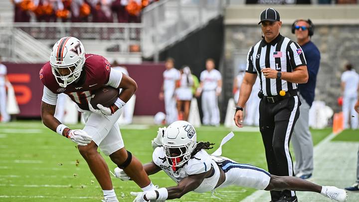 Sep 12, 2026; Blacksburg, Virginia, USA;  Virginia Tech Hokies wide receiver Davion Brown (11) runs after a catch as Old Dominion Monarchs cornerback Zion Frink (1) attempts to tackle during the first quarter at Lane Stadium.  Mandatory Credit: Brian Bishop-Imagn Images