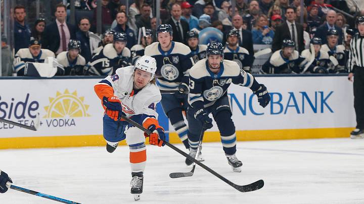 Dec 28, 2025; Columbus, Ohio, USA; New York Islanders right wing Maxim Shabanov (49) passes the puck as Columbus Blue Jackets center Sean Monahan (23) trails the play during the first period at Nationwide Arena. Mandatory Credit: Russell LaBounty-Imagn Images