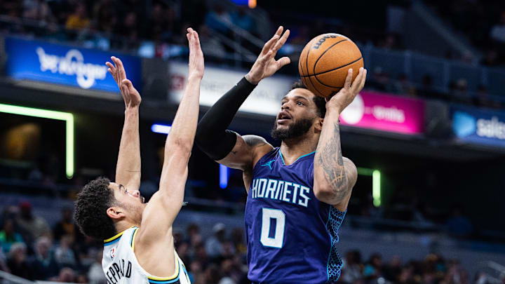 Apr 2, 2025; Indianapolis, Indiana, USA; Charlotte Hornets forward Miles Bridges (0) shoots the ball while Indiana Pacers guard Ben Sheppard (26) defends in the first half at Gainbridge Fieldhouse. Mandatory Credit: Trevor Ruszkowski-Imagn Images