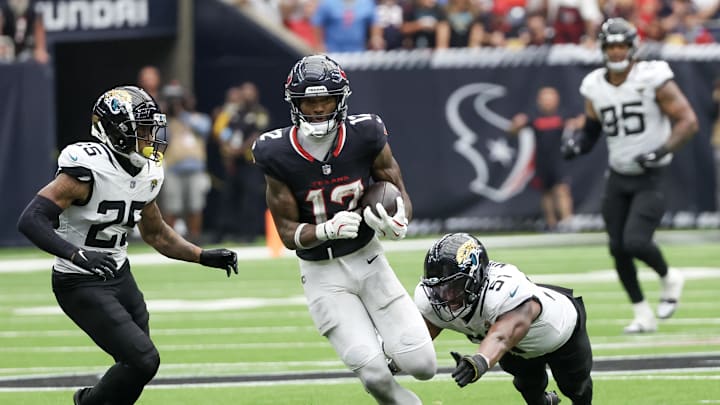 Sep 29, 2024; Houston, Texas, USA; Jacksonville Jaguars wide receiver Devin Duvernay (12) runs after the catch against Jacksonville Jaguars linebacker Ventrell Miller (51) in the second half at NRG Stadium. Mandatory Credit: Thomas Shea-Imagn Images