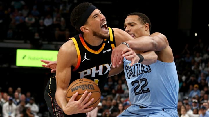 Mar 10, 2025; Memphis, Tennessee, USA; Phoenix Suns guard Devin Booker (1) drives to the basket as Memphis Grizzlies guard Desmond Bane (22) defends during the fourth quarter at FedExForum. Mandatory Credit: Petre Thomas-Imagn Images