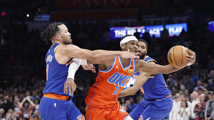 Oklahoma City Thunder guard Shai Gilgeous-Alexander drives between New York Knicks guards Jalen Brunson and Mikal Bridges. Mandatory Credit: Alonzo Adams-Imagn Images