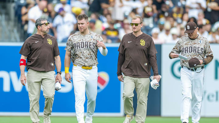 Jun 1, 2025; San Diego, California, USA; San Diego Padres left fielder Gavin Sheets (30) walking off the field with manager Mike Shildt (8) and training staff during the fourth inning against the Pittsburgh Pirates at Petco Park. Mandatory Credit: David Frerker-Imagn Images