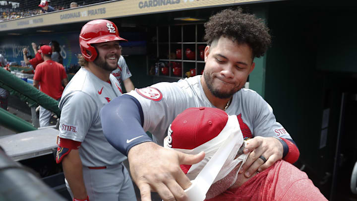 Jul 24, 2024; Pittsburgh, Pennsylvania, USA;  St. Louis Cardinals designated hitter Willson Contreras (middle) warps hitting coach Turner Ward (right) with athletic tape in the dugout before a game against  the Pittsburgh Pirates at PNC Park. Mandatory Credit: Charles LeClaire-Imagn Images
