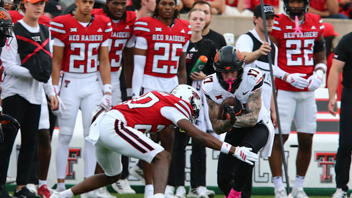 Oct 25, 2025; Lubbock, Texas, USA;  Oklahoma State Cowboys wide receiver Gavin Freeman (17) is tackled by Texas Tech Red Raiders defensive back Dontae Balfour (20) in the first half at Jones AT&T Stadium. Mandatory Credit: Michael C. Johnson-Imagn Images