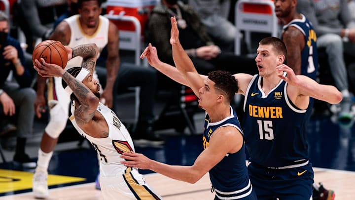 Mar 21, 2021; Denver, Colorado, USA; New Orleans Pelicans forward Brandon Ingram (L) controls the ball while defended by Denver Nuggets forward Michael Porter Jr. (C) and center Nikola Jokic (15) during the first quarter at Ball Arena. Mandatory Credit: Isaiah J. Downing-Imagn Images