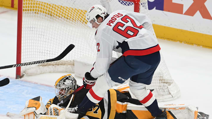 Apr 11, 2026; Pittsburgh, Pennsylvania, USA;  Washington Capitals right wing left wing Ilya Protas (62) pressures Pittsburgh Penguins goalie Arturs Silovs (37) on a goal during the second period at PPG Paints Arena. Mandatory Credit: Philip G. Pavely-Imagn Images