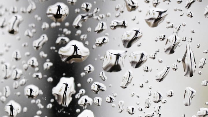 A statue of Curly Lambeau is seen through rain drops at Lambeau Field.