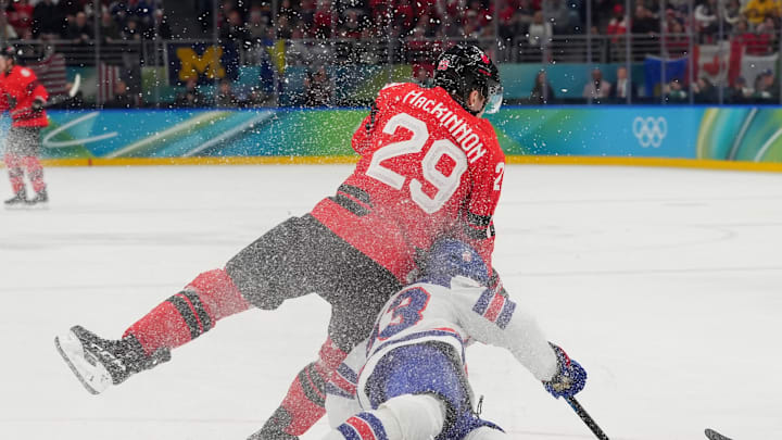 Feb 22, 2026; Milan, Italy; Nathan MacKinnon (29) of Canada and Quinn Hughes (43) of the United States in action in the men's ice hockey gold medal game during the Milano Cortina 2026 Olympic Winter Games at Milano Santagiulia Ice Hockey Arena. Mandatory Credit: Amber Searls-Imagn Images Feb 22, 2026; Milan, Italy; Nathan MacKinnon (29) of Canada and Quinn Hughes (43) of the United States in action in the men's ice hockey gold medal game during the Milano Cortina 2026 Olympic Winter Games at Milano Santagiulia Ice Hockey Arena. Mandatory Credit: Amber Searls-Imagn Images