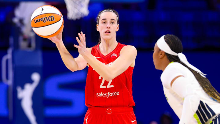 Jul 17, 2024; Arlington, Texas, USA;  Indiana Fever guard Caitlin Clark (22) passes the ball past Dallas Wings guard Odyssey Sims (2) during the second half at College Park Center. Mandatory Credit: Kevin Jairaj-Imagn Images