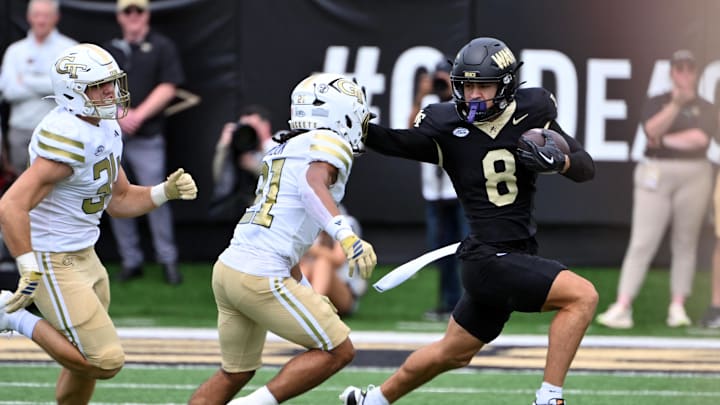 Sep 27, 2025; Winston-Salem, North Carolina, USA;  Wake Forest Demon Deacons wide receiver Carlos Hernandez (8) runs the ball against Georgia Tech Yellow Jackets defensive back Elgin Sessions (21) during the first quarter at Allegacy Federal Credit Union Stadium. Mandatory Credit: Zachary Taft-Imagn Images