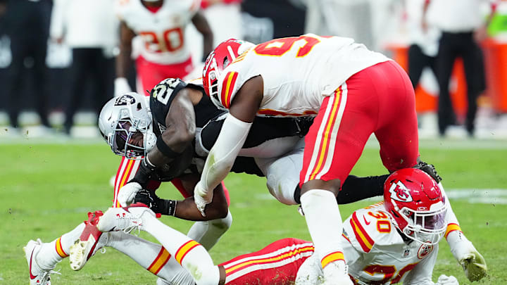 Oct 27, 2024; Paradise, Nevada, USA; Las Vegas Raiders running back Alexander Mattison (22) is tackled by Kansas City Chiefs cornerback Christian Roland-Wallace (30) and Kansas City Chiefs defensive tackle Tershawn Wharton (98) during the fourth quarter at Allegiant Stadium. Mandatory Credit: Stephen R. Sylvanie-Imagn Images