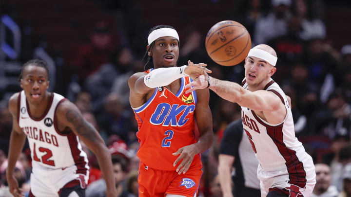 Jan 13, 2023; Chicago, Illinois, USA; Oklahoma City Thunder guard Shai Gilgeous-Alexander (2) passes the ball against Chicago Bulls guard Alex Caruso (6) during the first half at United Center. Mandatory Credit: Kamil Krzaczynski-USA TODAY Sports