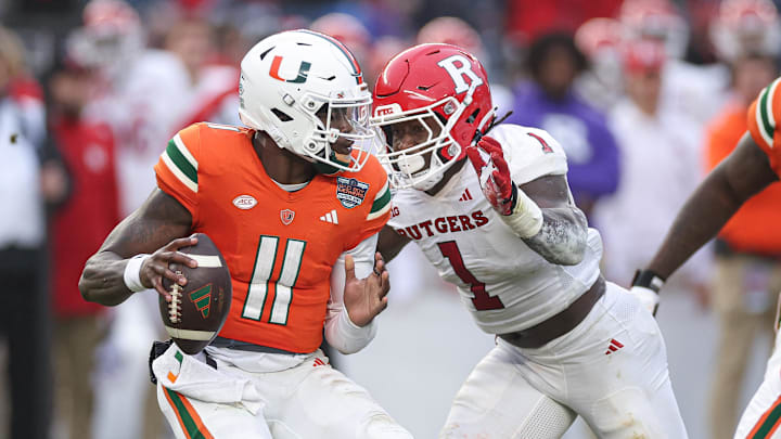 Dec 28, 2023; Bronx, NY, USA; Miami Hurricanes quarterback Jacurri Brown (11) is sacked by Rutgers Scarlet Knights linebacker Mohamed Toure (1) during the first half of the 2023 Pinstripe Bowl at Yankee Stadium. Mandatory Credit: Vincent Carchietta-Imagn Images