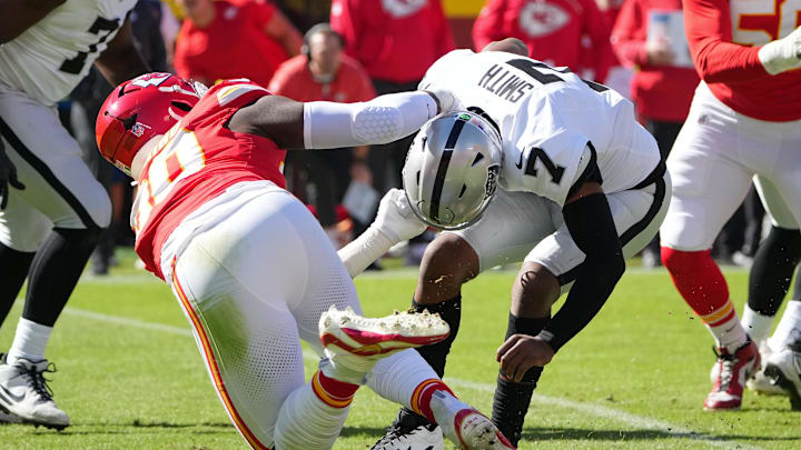 Oct 19, 2025; Kansas City, Missouri, USA; Kansas City Chiefs defensive end Charles Omenihu (90) sacks Las Vegas Raiders quarterback Geno Smith (7) during the first quarter of the game at GEHA Field at Arrowhead Stadium. Mandatory Credit: Denny Medley-Imagn Images