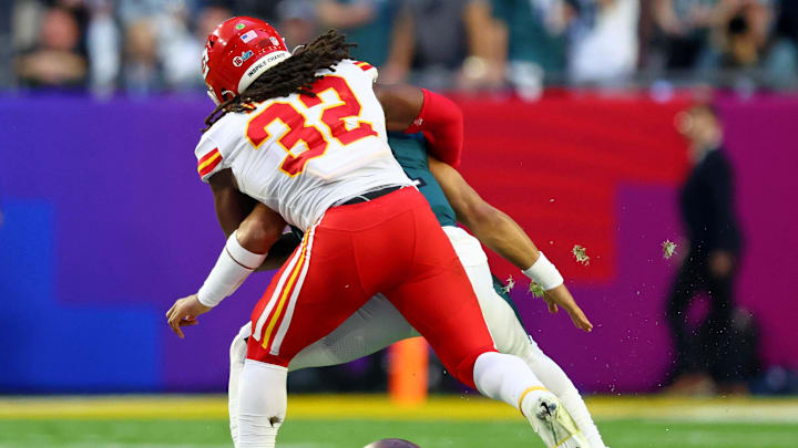 Feb 12, 2023; Glendale, Arizona, US; Kansas City Chiefs linebacker Nick Bolton (32) forces a fumble against Philadelphia Eagles quarterback Jalen Hurts (1) during the second quarter of Super Bowl LVII at State Farm Stadium. 