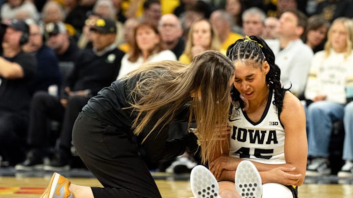An Iowa athletic trainer talks to Iowa forward Hannah Stuelke (45) during a basketball game against the Illinois Fighting Illini Feb. 26, 2026 at Carver-Hawkeye Arena in Iowa City, Iowa.