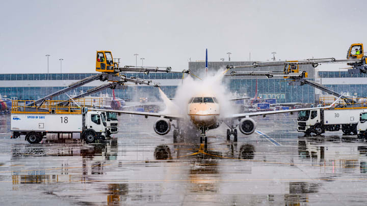 Workers spray deicing fluid on an airplane at Denver International Airport on Wednesday, Nov. 27, 2024, during a snowstorm. The deicing fluid sticks to surfaces so that snow and ice can't build up when airplanes are waiting to take off in snowy conditions.