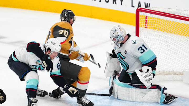 Dec 21, 2024; Las Vegas, Nevada, USA; Seattle Kraken goaltender Philipp Grubauer (31) makes a save against Vegas Golden Knights left wing Tanner Pearson (70) as Seattle Kraken defenseman Brandon Montour (62) looks to break up the play during the third period at T-Mobile Arena. Mandatory Credit: Stephen R. Sylvanie-Imagn Images