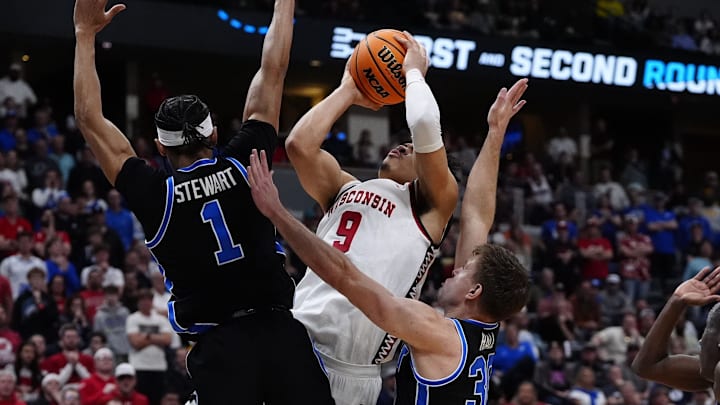 Mar 22, 2025; Denver, CO, USA; Wisconsin Badgers guard John Tonje (9) shoots the ball over Brigham Young Cougars guard Trey Stewart (1) during the second half in the second round of the NCAA Tournament  at Ball Arena. 