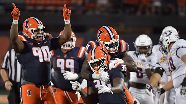 Aug 29, 2025; Champaign, Illinois, USA;  Illinois Fighting Illini linebacker Gabe Jacas (17) jumps on teammate Illinois Fighting Illini defensive lineman Eli Coenen (96) after a sack on Western Illinois Leathernecks quarterback Chris Irvin (5) during the first half at Memorial Stadium. Mandatory Credit: Ron Johnson-Imagn Images