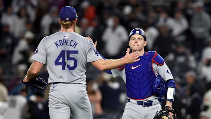 Los Angeles Dodgers pitcher Michael Kopech (45) celebrates with catcher Will Smith (16) after winning game three of the 2024 MLB World Series against the New York Yankees at Yankee Stadium.