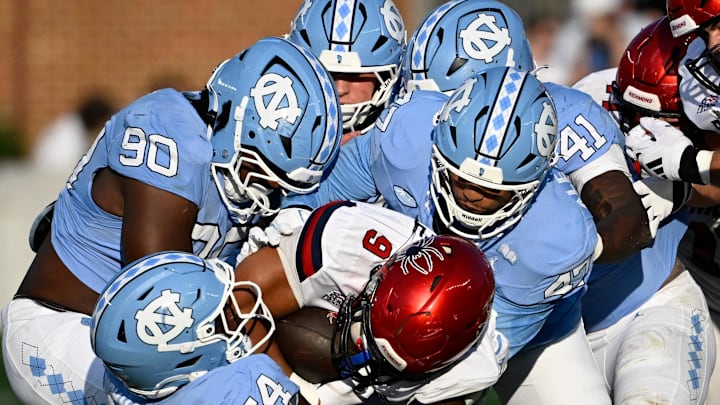Sep 13, 2025; Chapel Hill, North Carolina, USA; North Carolina Tar Heels defensive lineman Xavier Lewis (90) and linebackers Timir Hickman-Collins (54) and Austin Alexander (47) tackle Richmond Spiders running back Michael Creamer (9) in the fourth quarter at Kenan Stadium. Mandatory Credit: Bob Donnan-Imagn Images Sep 13, 2025; Chapel Hill, North Carolina, USA; North Carolina Tar Heels defensive lineman Xavier Lewis (90) and linebackers Timir Hickman-Collins (54) and Austin Alexander (47) tackle Richmond Spiders running back Michael Creamer (9) in the fourth quarter at Kenan Stadium. Mandatory Credit: Bob Donnan-Imagn Images