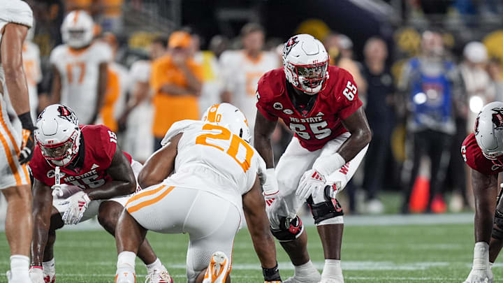 Sep 7, 2024; Charlotte, North Carolina, USA; North Carolina State Wolfpack offensive tackle Jacarrius Peak (65) lines up against Tennessee Volunteers defensive lineman Bryson Eason (20) during the first quarter at the Dukes Mayo Classic at Bank of America Stadium. Mandatory Credit: Jim Dedmon-Imagn Images