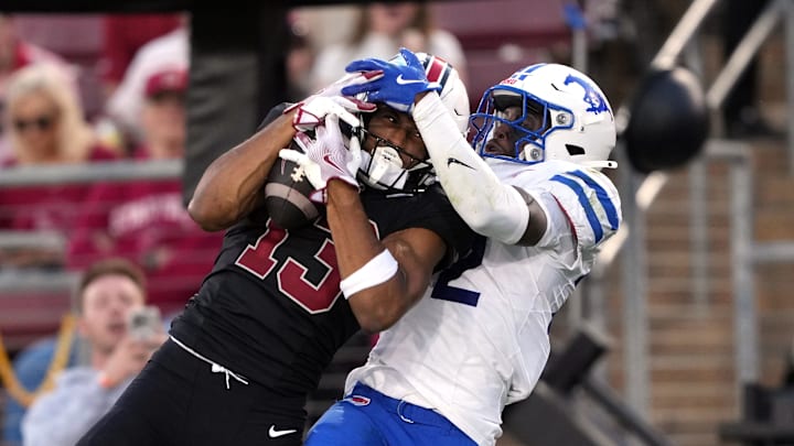 Oct 19, 2024; Stanford, California, USA; Stanford Cardinal wide receiver Elic Ayomanor (left) catches a touchdown pass against Southern Methodist Mustangs safety Cale Sanders Jr. (right) during the second quarter at Stanford Stadium. Mandatory Credit: Darren Yamashita-Imagn Images