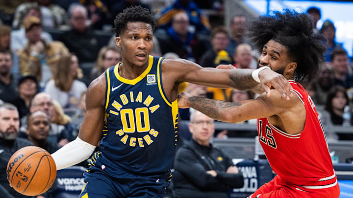 Jan 8, 2025; Indianapolis, Indiana, USA; Indiana Pacers guard Bennedict Mathurin (00) dribbles the ball while Chicago Bulls guard Coby White (0) defends in the second half at Gainbridge Fieldhouse. Mandatory Credit: Trevor Ruszkowski-Imagn Images