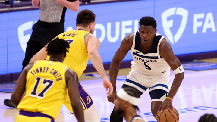 Apr 22, 2025; Los Angeles, California, USA; Minnesota Timberwolves guard Anthony Edwards (5) dribbles the ball against Los Angeles Lakers guard Luka Doncic (77) during the first quarter of game two of first round for the 2024 NBA Playoffs at Crypto.com Arena. Mandatory Credit: Kiyoshi Mio-Imagn Images