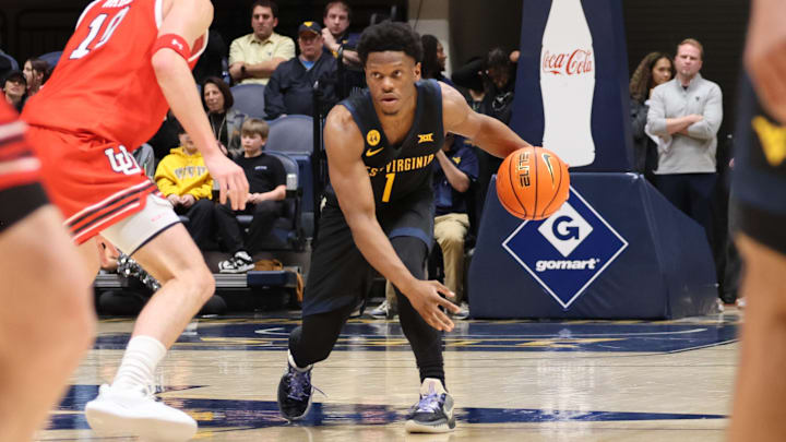 West Virginia University guard Joseph Yesufu brings the ball up the floor against Utah.