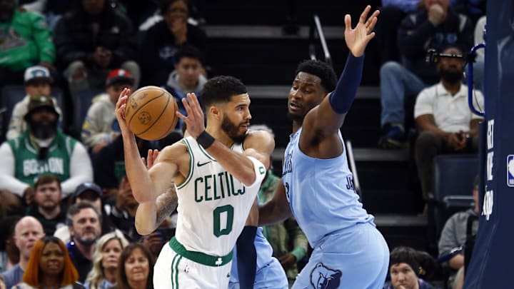Mar 31, 2025; Memphis, Tennessee, USA; Boston Celtics forward Jayson Tatum (0) passes the ball as Memphis Grizzlies forward Jaren Jackson Jr. (13) defends during the fourth quarter at FedExForum. Mandatory Credit: Petre Thomas-Imagn Images