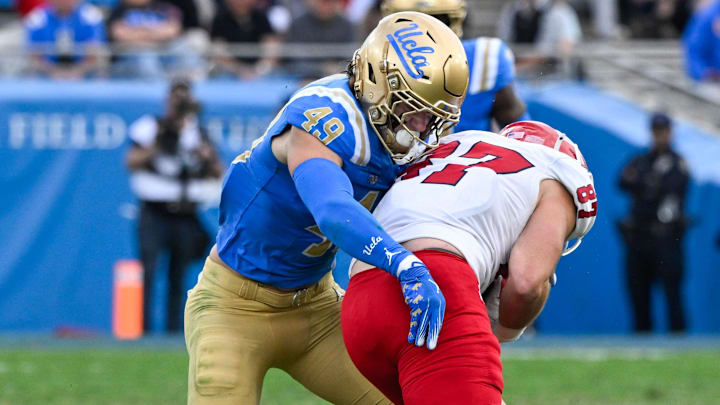 Nov 30, 2024; Pasadena, California, USA; UCLA Bruins linebacker Carson Schwesinger (49) Fresno State Bulldogs tight end Jake Tarwater (87) during the third quarter at Rose Bowl. Mandatory Credit: Robert Hanashiro-Imagn Images