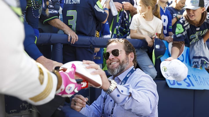 Oct 6, 2024; Seattle, Washington, USA; Seattle Seahawks general manager John Schneider signs sutographs during pregame warmups against the New York Giants at Lumen Field. Oct 6, 2024; Seattle, Washington, USA; Seattle Seahawks general manager John Schneider signs sutographs during pregame warmups against the New York Giants at Lumen Field.