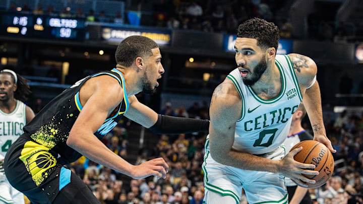 Boston Celtics forward Jayson Tatum (0) holds the ball while Indiana Pacers guard Tyrese Haliburton.