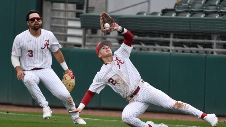 Feb 17, 2024; Tuscaloosa, Alabama, USA; Alabama second baseman Mason Swinney makes a difficult catch on a fly ball behind first base with right fielder Evan Sleight backing him up during the game with Manhattan at Sewell-Thomas Stadium Saturday.