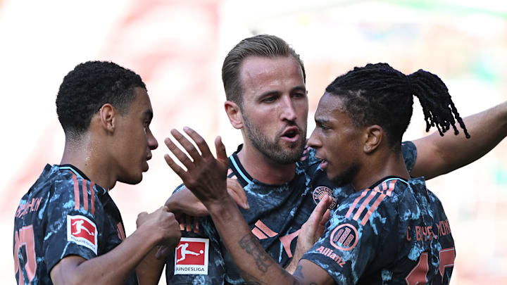 Bayern Munich forwards Jamal Musiala, Harry Kane, and Michael Olise celebrating a goal against Werder Bremen.