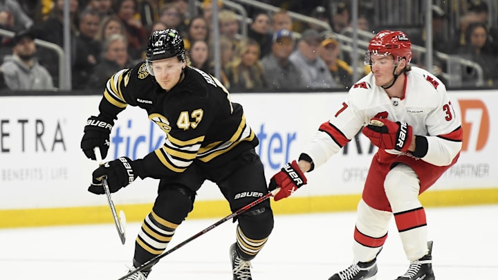 Apr 9, 2024; Boston, Massachusetts, USA; Boston Bruins center Danton Heinen (43) tries to gain control of the puck ahead of Carolina Hurricanes right wing Andrei Svechnikov (37) during the first period at TD Garden. Mandatory Credit: Bob DeChiara-USA TODAY Sports