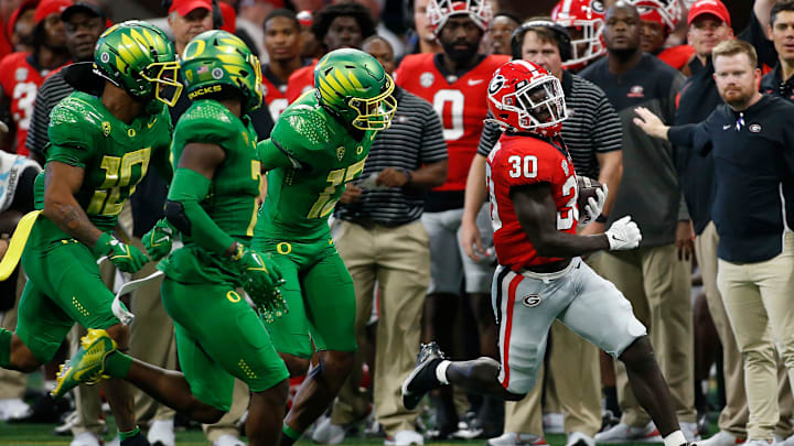 Georgia running back Daijun Edwards (30) drives the ball down the field to avoid a flock of Ducks.