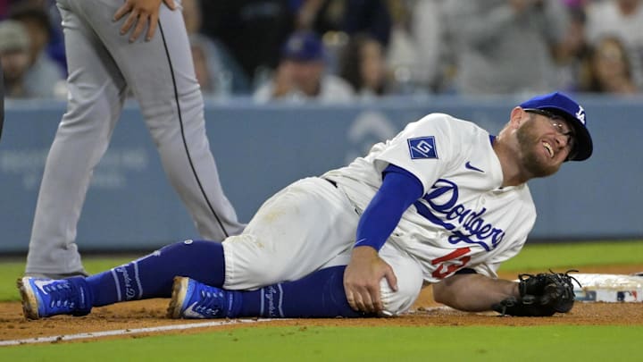 Jul 2, 2025; Los Angeles, California, USA;  Los Angeles Dodgers third baseman Max Muncy (13) grabs his knee after tagging Chicago White Sox right fielder Michael A. Taylor (21) out on an attempted stolen base during the fifth inning at Dodger Stadium. Mandatory Credit: Jayne Kamin-Oncea-Imagn Images