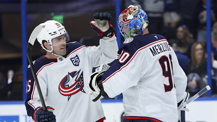 Blue Jackets defenseman Dante Fabbro celebrates an empty net goal with goaltender Elvis Merzlikins, who picked up the assist.