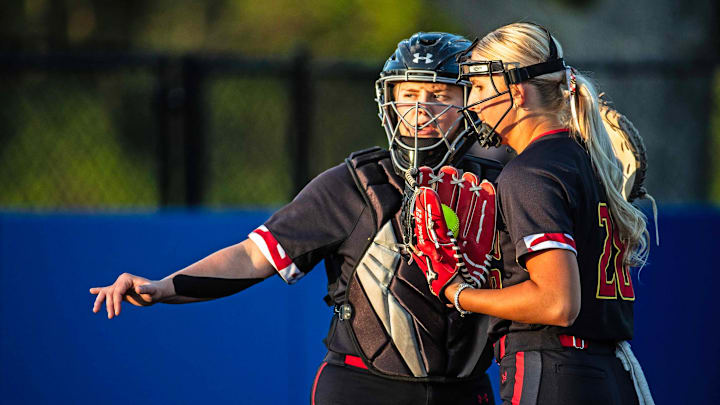 Maryland freshman Aubrey Wurst (28) confers with senior Sam Bean (9) against Delaware in a non-conference girls softball game at the Delaware softball field in Newark. 