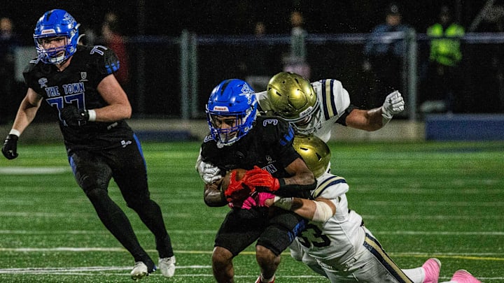 Middletown senior John Parker (3) hangs onto the ball as Salesianum senior Cummings Mitchell (33) and sophomore Patrick Dillon (22) wrap him up for the takedown during football game at the Cavaliers Stadium in Middletown, Friday, Oct. 25, 2024. Salesianum won 38-7.