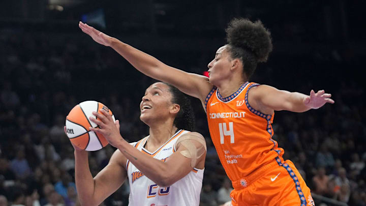 Phoenix Mercury forward Alyssa Thomas (25) lays the ball up past Connecticut Sun guard Bria Hartley (14) during the first quarter at PHX Arena on Aug. 5, 2025, in Phoenix.