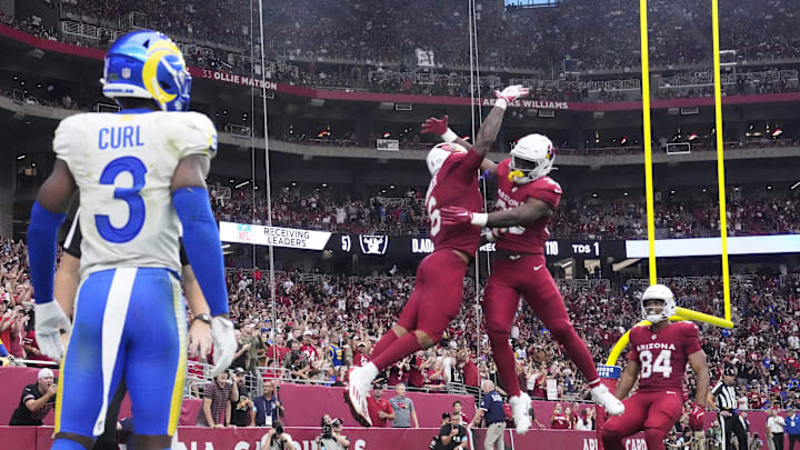 Arizona Cardinals running back James Conner (6) celebrates his touchdown run with running back Trey Benson (33) during the third quarter against the Los Angeles Rams at State Farm Stadium.